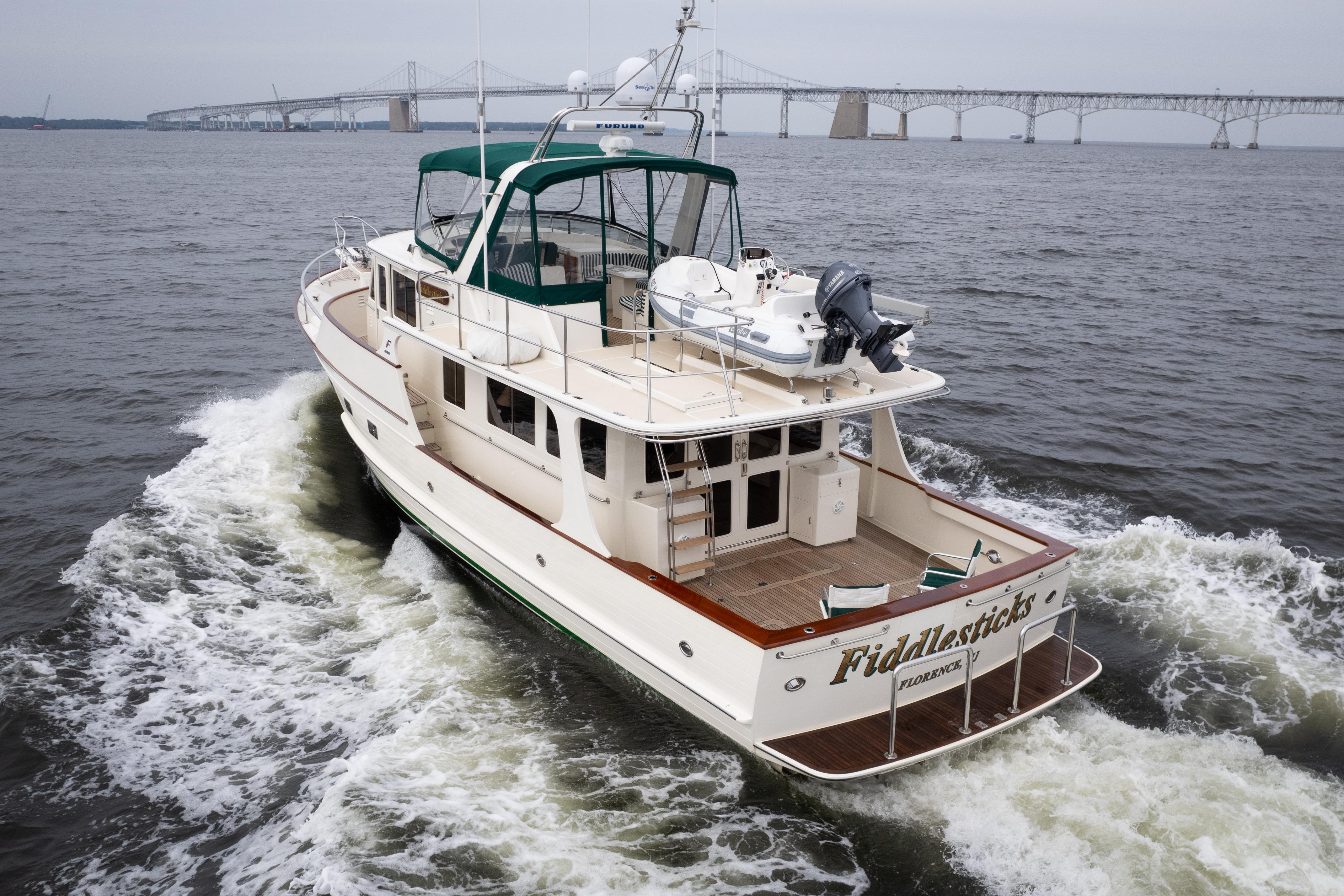 Fleming 55 yacht cruising on water, 2007 model, with bridge in background.
