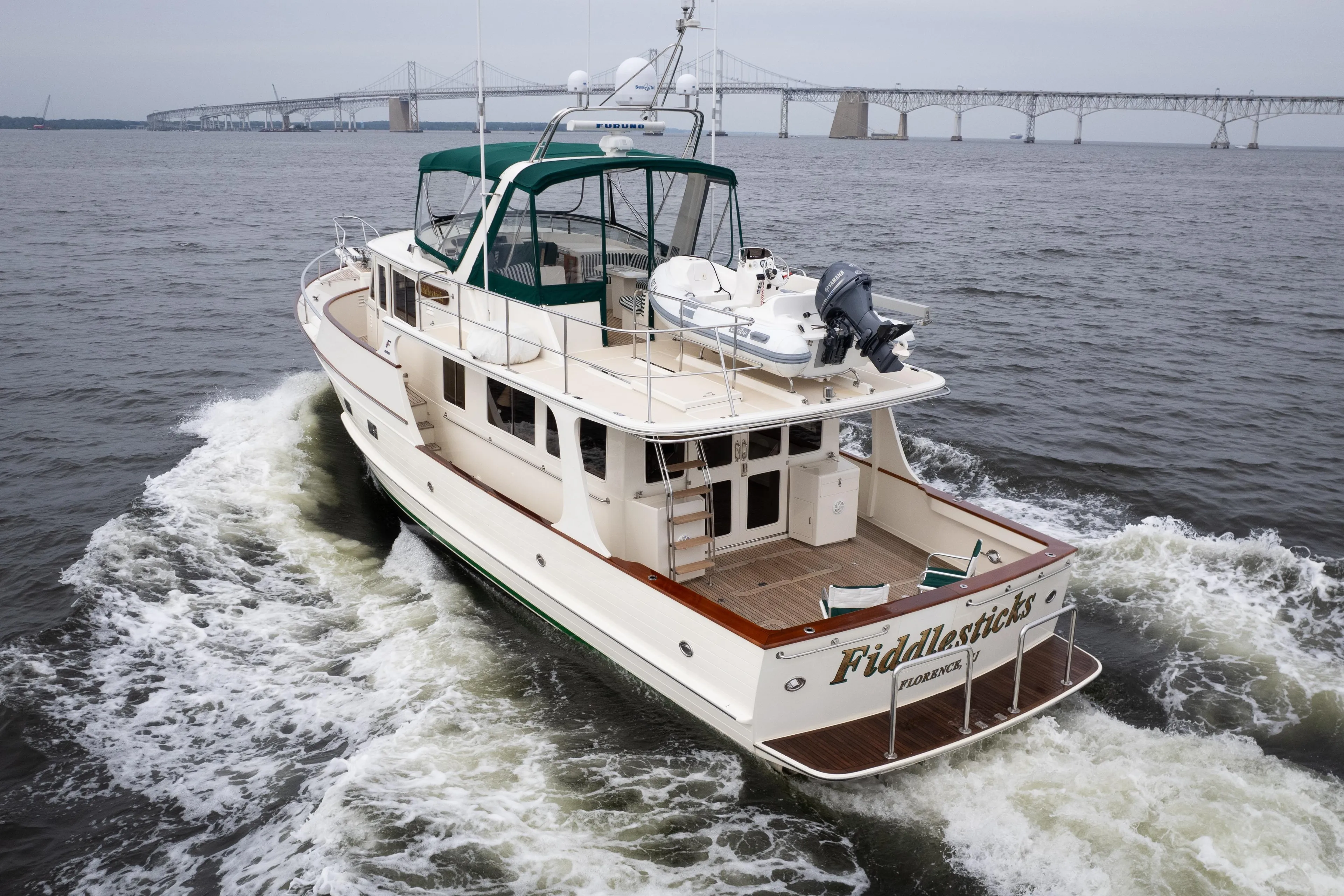 Fleming 55 yacht cruising on water, 2007 model, with bridge in background.