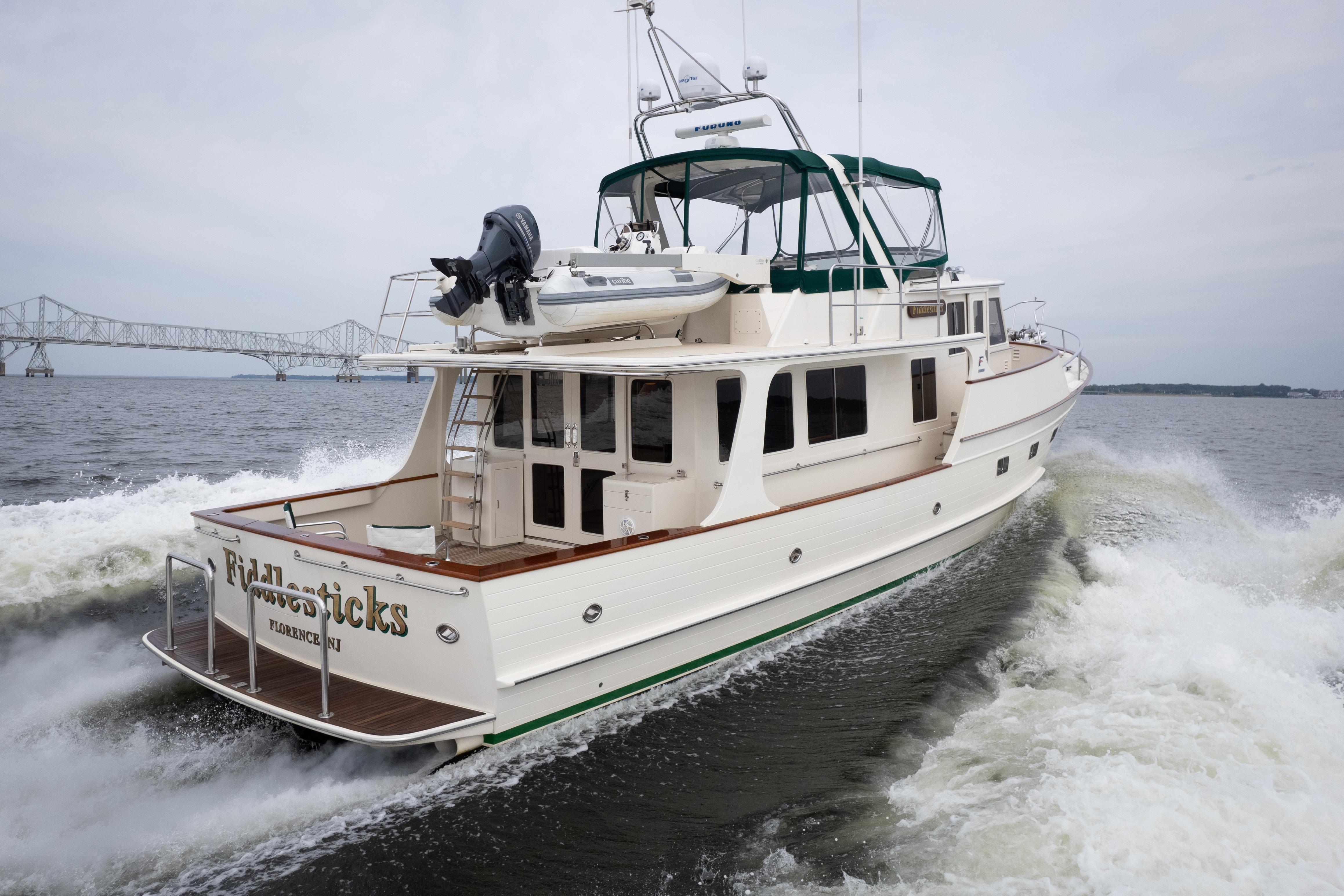 2007 Fleming 55 yacht cruising on water with bridge in background.
