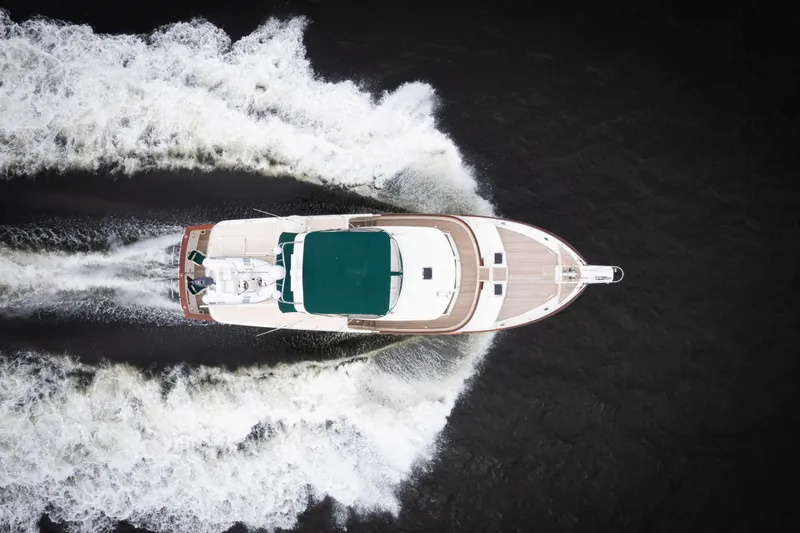 Fiddlesticks Yacht Photos Pics Aerial view of 2007 Fleming 55 yacht cruising through water, leaving a wake.