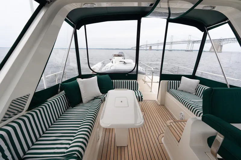 Fiddlesticks Yacht Photos Pics Luxurious 2007 Fleming 55 yacht interior with striped seating, table, and scenic bridge view.