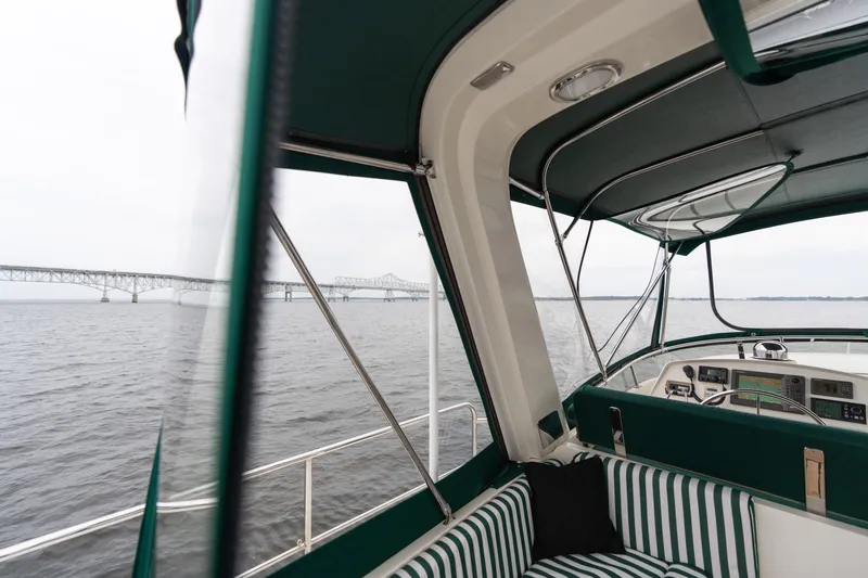 Fiddlesticks Yacht Photos Pics 2007 Fleming 55 yacht interior with striped seating, overlooking a bridge on the water.