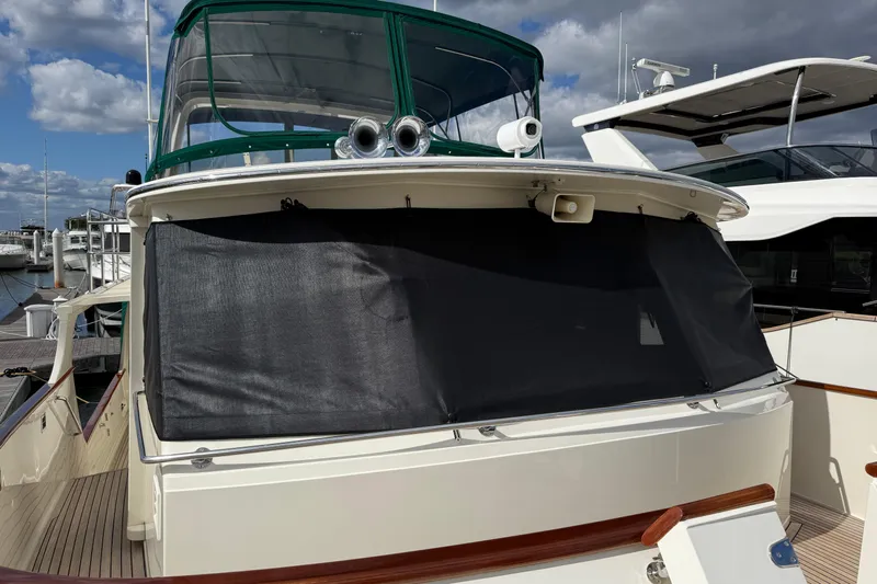 Fiddlesticks Yacht Photos Pics 2007 Fleming 55 yacht with covered windows docked at a marina under a cloudy sky.