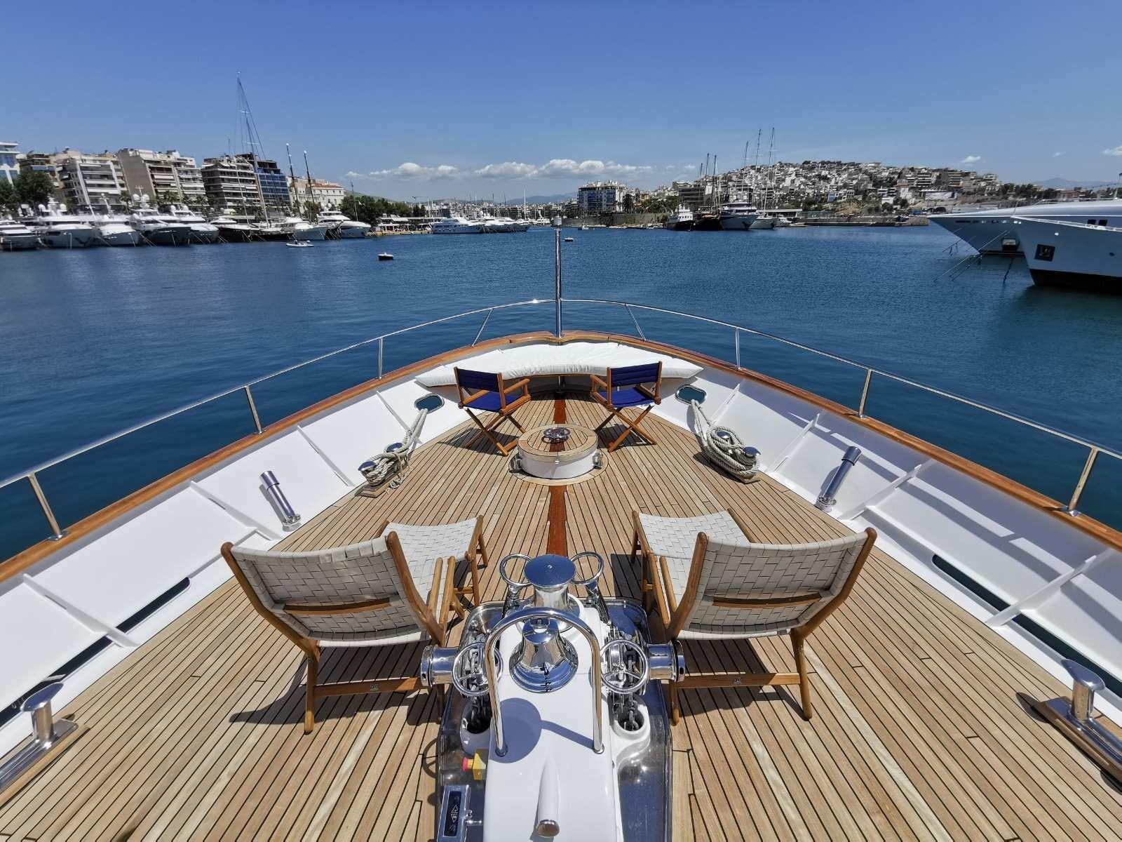 Luxurious 1988 Codecasa Displacement Yacht with elegant deck chairs and scenic harbor view.