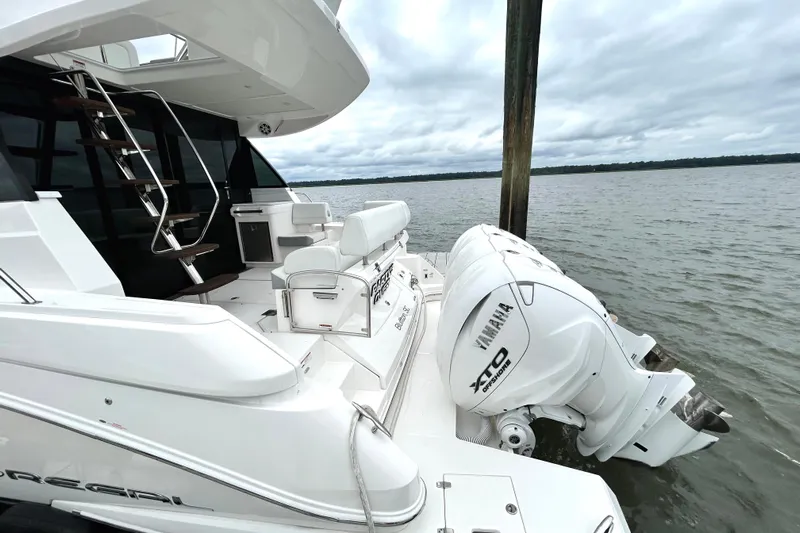 Party's Over Yacht Photos Pics 2024 Regal 42 FXO yacht with Yamaha XTO engines docked on a calm lake.