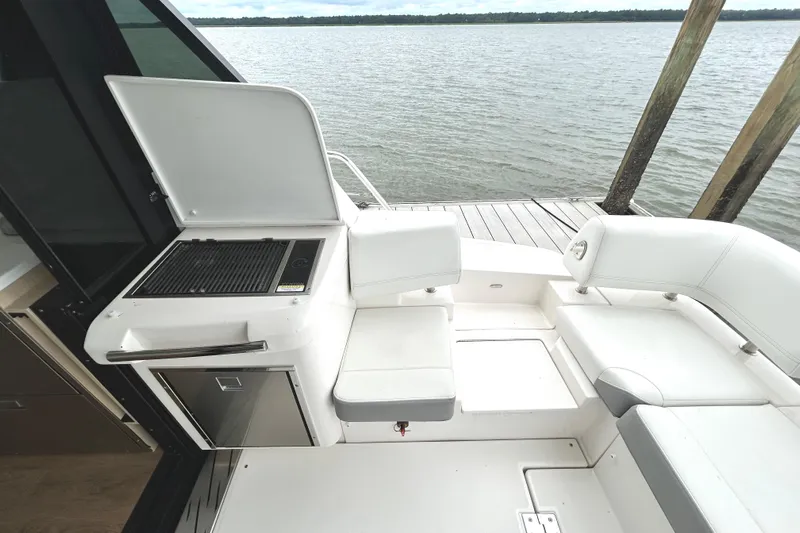 Party's Over Yacht Photos Pics 2024 Regal 42 FXO yacht with outdoor seating and grill by the water.