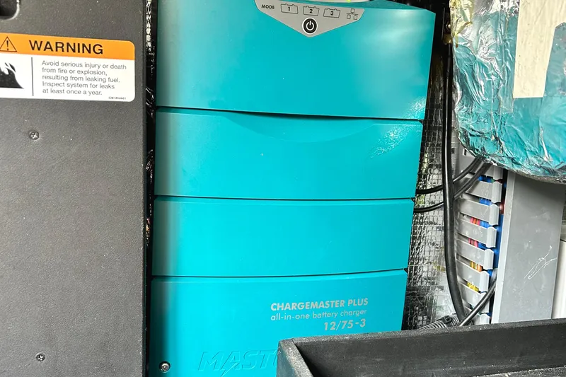 Party's Over Yacht Photos Pics Battery charger in 2024 Regal 42 FXO boat, with safety warning label visible.