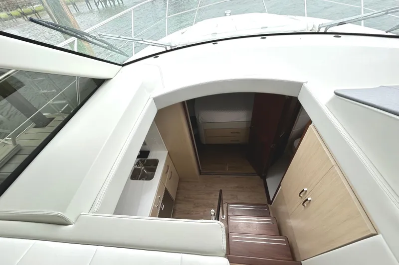 Party's Over Yacht Photos Pics 2024 Regal 42 FXO yacht interior with stairs, kitchenette, and cabin view.