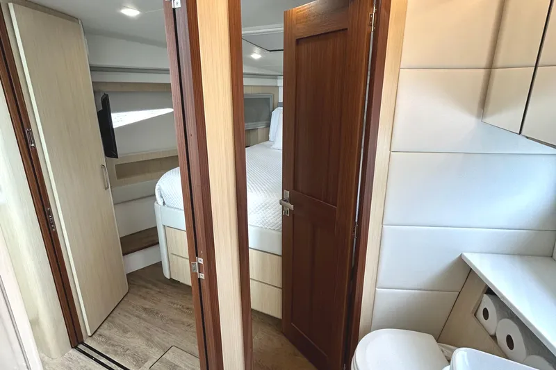Party's Over Yacht Photos Pics 2024 Regal 42 FXO yacht interior with bedroom, bathroom, and modern wood finishes.