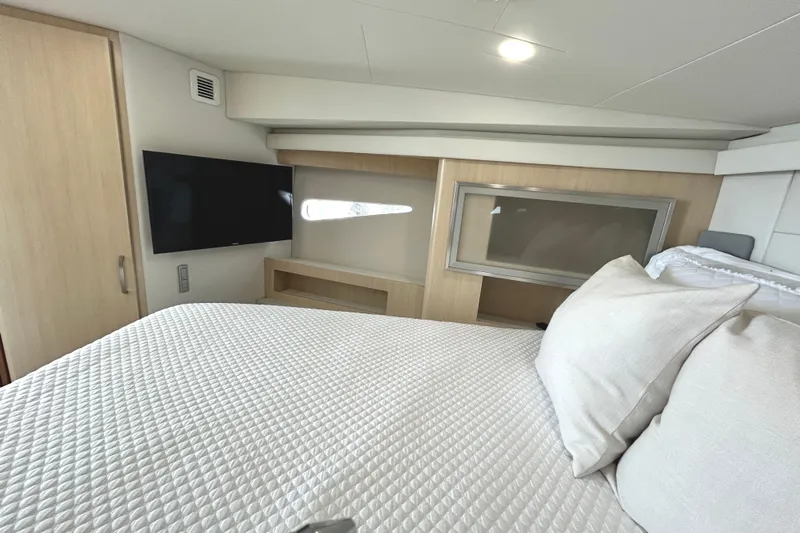 Party's Over Yacht Photos Pics Luxurious bedroom interior of 2024 Regal 42 FXO yacht with modern amenities.
