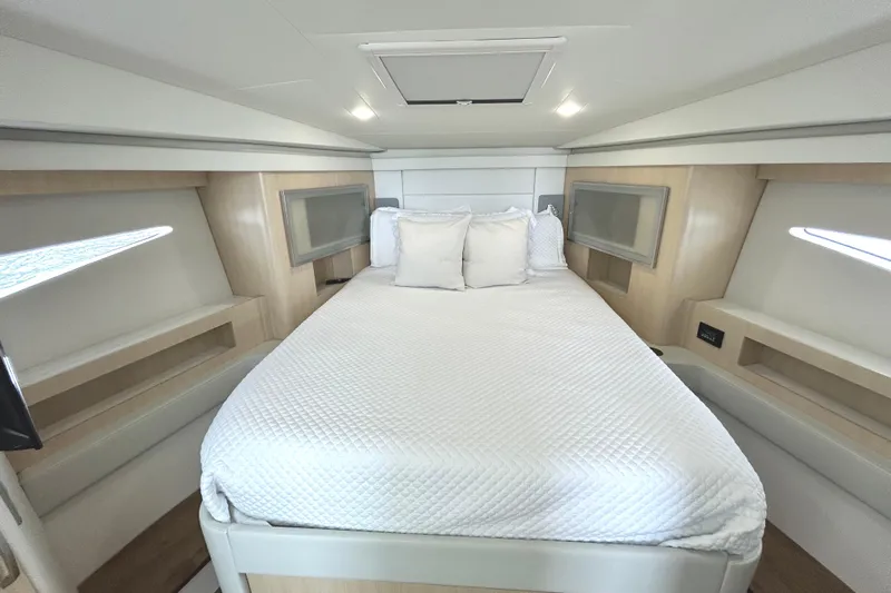 Party's Over Yacht Photos Pics Luxurious cabin interior of 2024 Regal 42 FXO yacht with cozy bed and modern design.