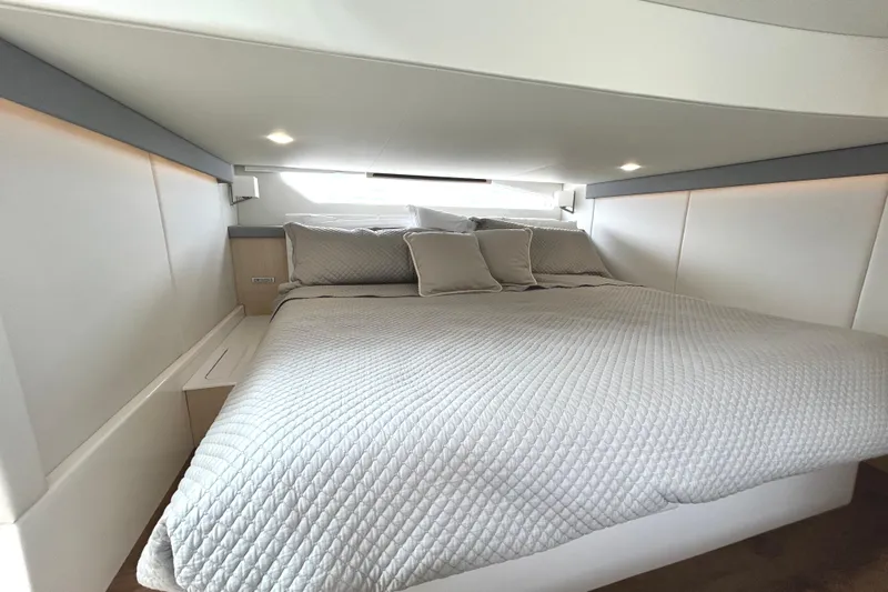 Party's Over Yacht Photos Pics Luxurious bedroom interior of 2024 Regal 42 FXO yacht with elegant bedding and modern design.