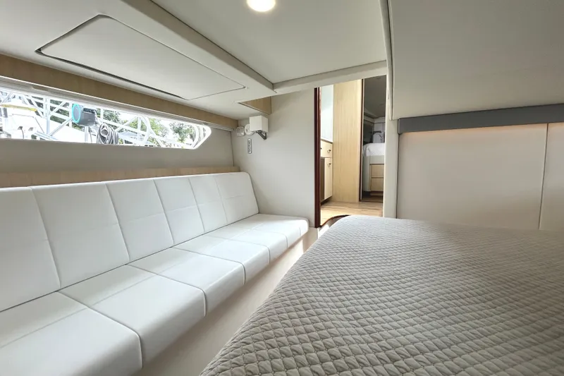 Party's Over Yacht Photos Pics Luxurious interior of 2024 Regal 42 FXO yacht with modern seating and bedding.