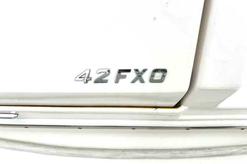 Party's Over Yacht Photos Pics 2024 Regal 42 FXO boat model emblem on white surface.