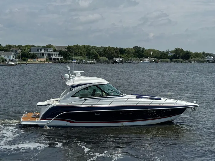  Yacht Photos Pics 2013 Formula 45 Yacht cruising on a calm river with houses in the background.