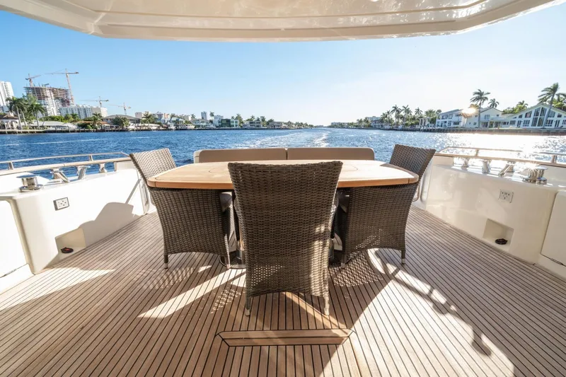  Yacht Photos Pics Luxurious 2020 Monte Carlo Yachts MCY 66 deck with elegant dining area, scenic waterfront view.