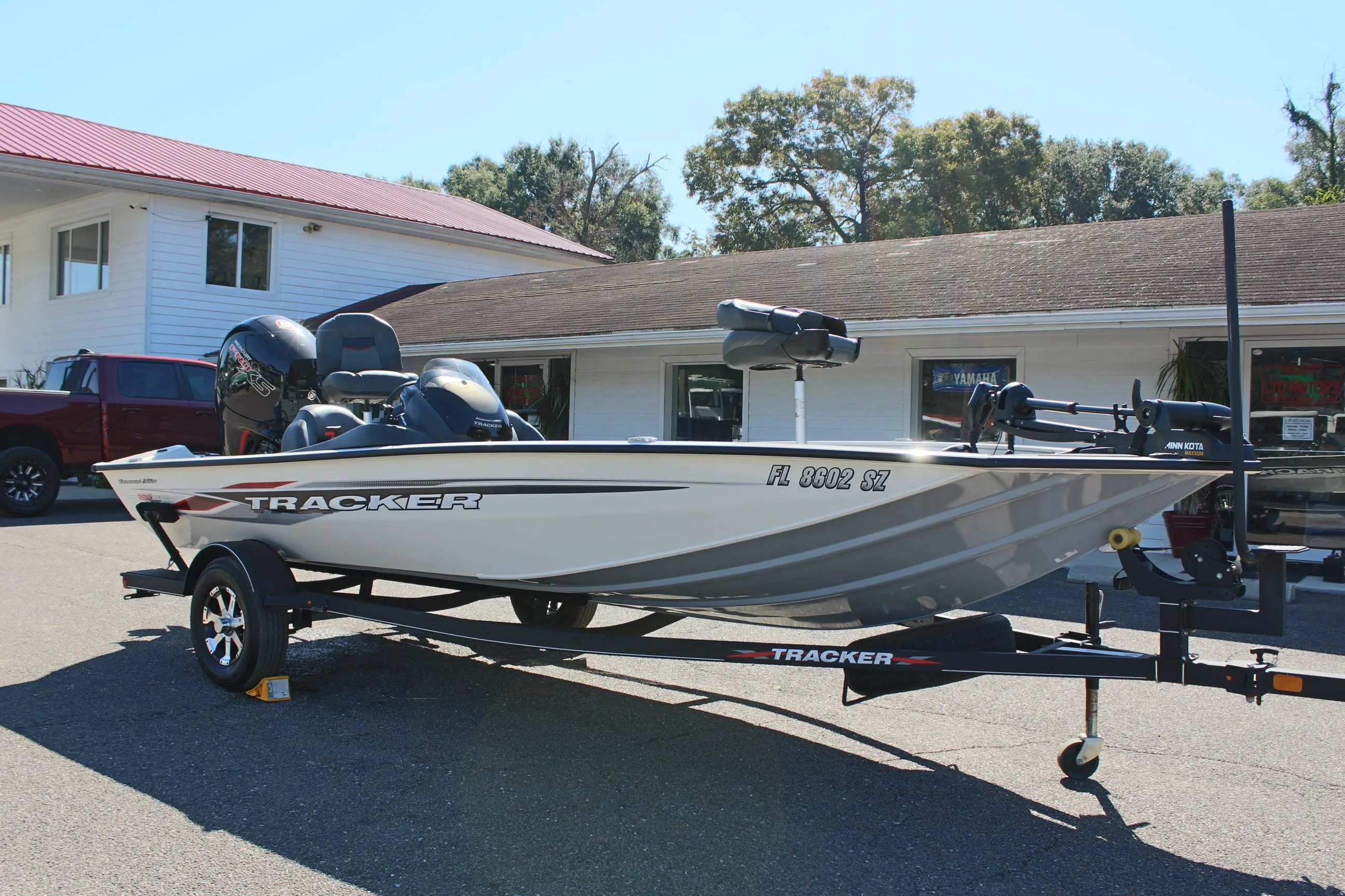 2021 Tracker 195 TXW Tournament Edition fishing boat on trailer in front of building.
