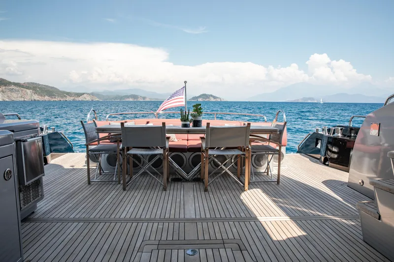  Yacht Photos Pics Luxury Sunseeker Predator 84 yacht deck with dining area, ocean view, and American flag.