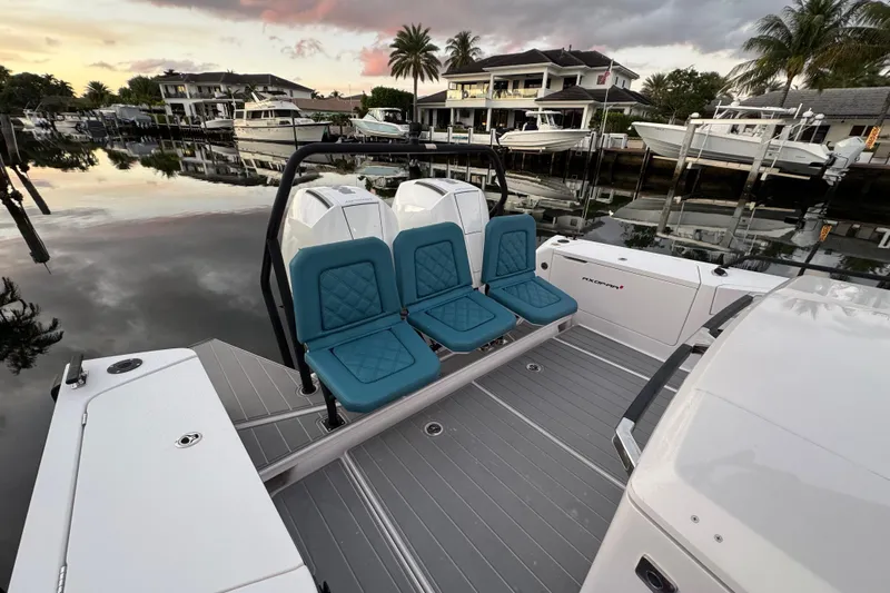  Yacht Photos Pics 2021 Axopar 37 boat with teal seats, docked at a serene waterfront during sunset.