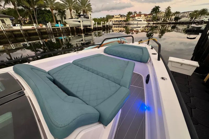  Yacht Photos Pics 2021 Axopar 37 boat with luxurious seating, docked near waterfront homes and palm trees.