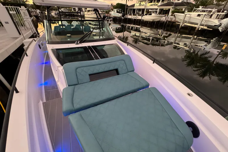  Yacht Photos Pics 2021 Axopar 37 boat with blue seating and ambient lighting at a marina.