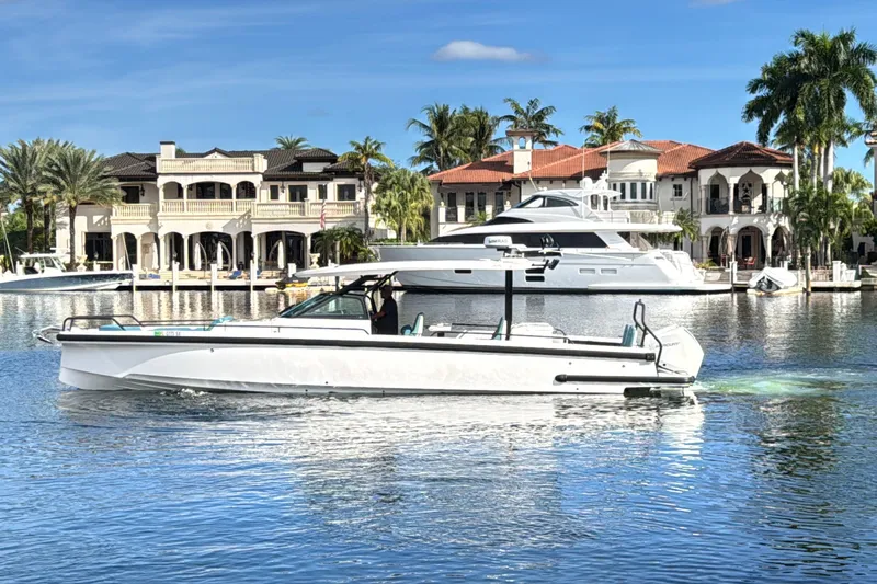  Yacht Photos Pics 2021 Axopar 37 Sun Top boat cruising near luxury waterfront homes.