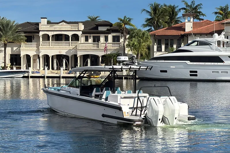  Yacht Photos Pics 2021 Axopar 37 Sun Top boat cruising near luxury waterfront homes.