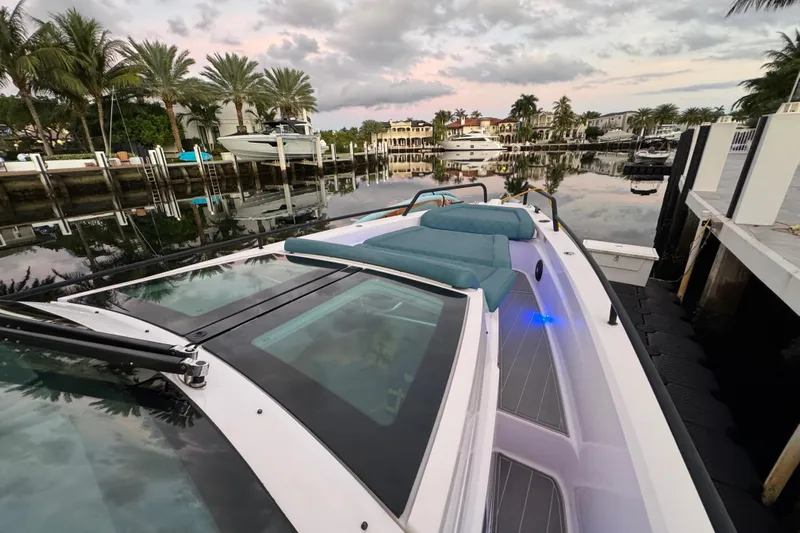  Yacht Photos Pics 2021 Axopar 37 Sun Top boat docked in a scenic marina with palm trees.