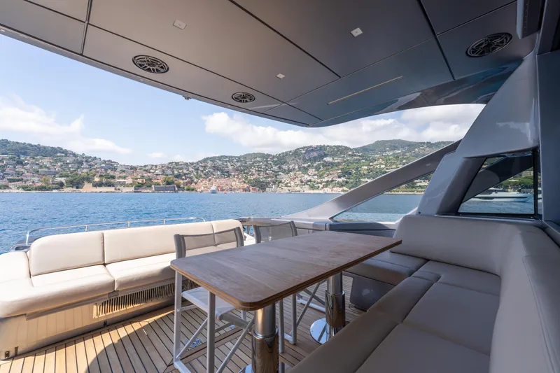 Ciao Yacht Photos Pics Luxurious 2024 Pershing 7X yacht deck with scenic coastal view.