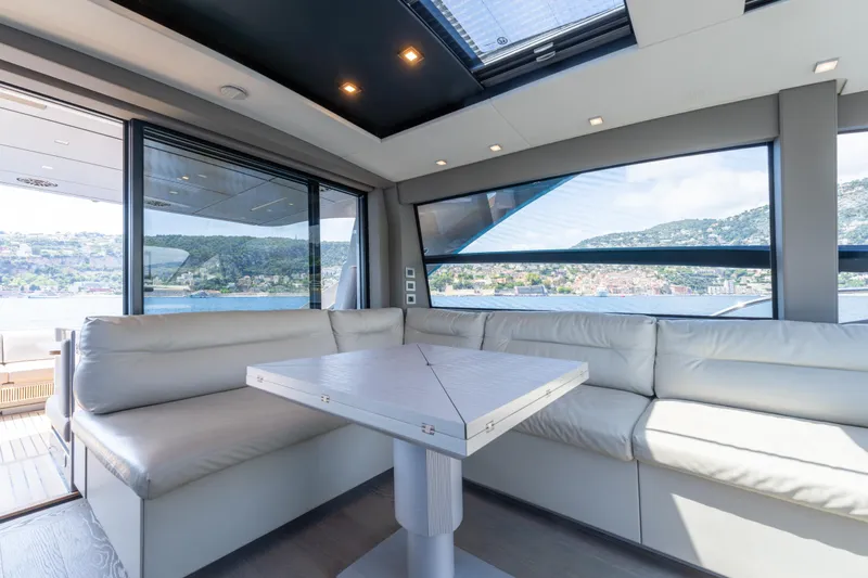 Ciao Yacht Photos Pics Luxurious interior of 2024 Pershing 7X yacht with panoramic windows and plush seating.