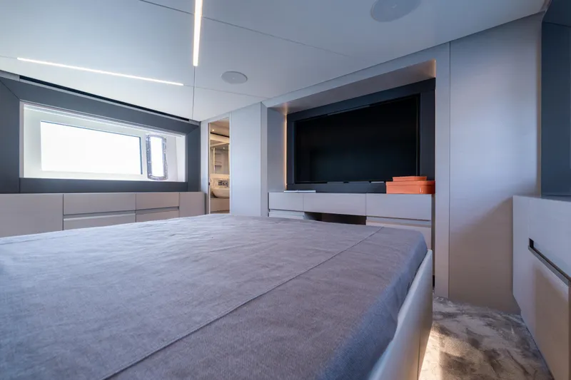 Ciao Yacht Photos Pics Luxurious interior of 2024 Pershing 7X yacht bedroom with modern design and large window.