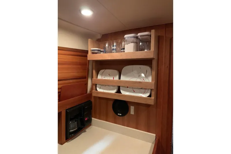  Yacht Photos Pics 2003 Mainship Pilot 34 galley with wooden shelves, plates, and storage jars.