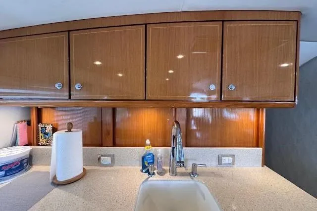 Pipe Dream Yacht Photos Pics 2005 Ocean Yachts 50 Super Sport kitchen with wooden cabinets and modern sink.
