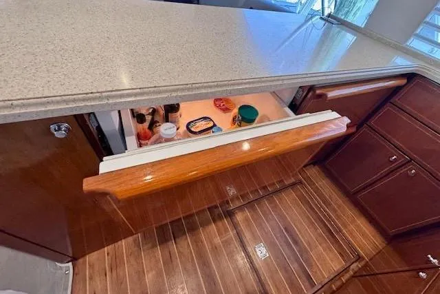 Pipe Dream Yacht Photos Pics 2005 Ocean Yachts 50 Super Sport galley with open drawer refrigerator and wooden flooring.