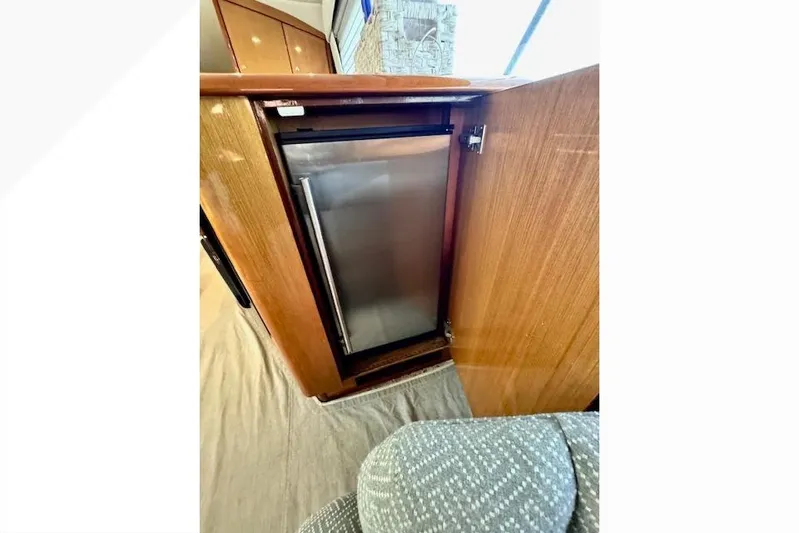 Pipe Dream Yacht Photos Pics 2005 Ocean Yachts 50 Super Sport interior with built-in mini fridge and wooden cabinetry.