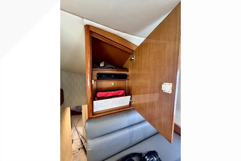 Pipe Dream Yacht Photos Pics Open wooden cabinet in 2005 Ocean Yachts 50 Super Sport interior, showing organized storage.