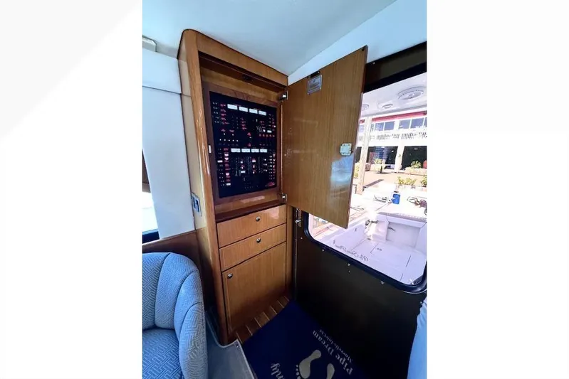 Pipe Dream Yacht Photos Pics Electrical panel inside 2005 Ocean Yachts 50 Super Sport, featuring wooden cabinetry and seating.