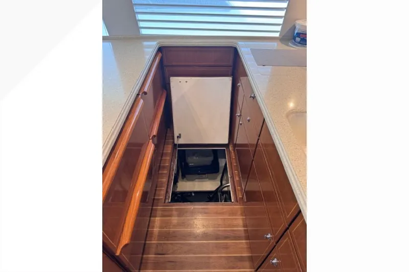 Pipe Dream Yacht Photos Pics Engine room access on 2005 Ocean Yachts 50 Super Sport, featuring wooden cabinetry and flooring.