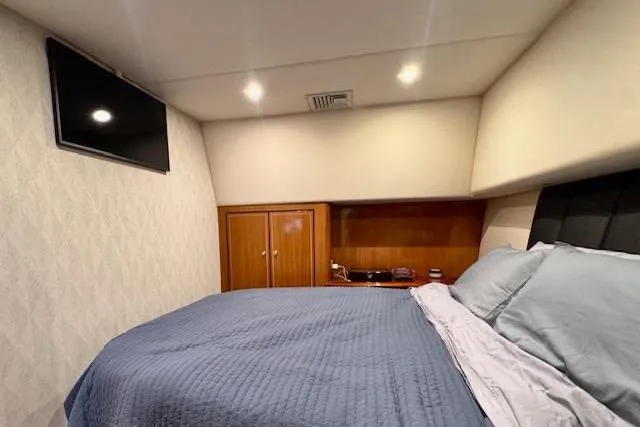 Pipe Dream Yacht Photos Pics Luxurious bedroom interior of 2005 Ocean Yachts 50 Super Sport with cozy bedding and TV.