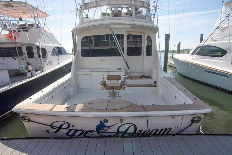 Pipe Dream Yacht Photos Pics 2005 Ocean Yachts 50 Super Sport docked, rear view with fishing chair and "Pipe Dream" name.