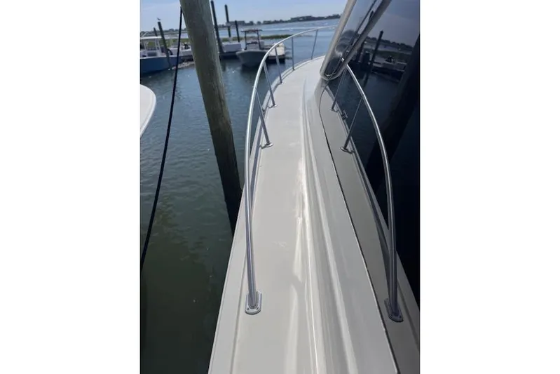 Pipe Dream Yacht Photos Pics 2005 Ocean Yachts 50 Super Sport yacht deck with railing, docked by the water.