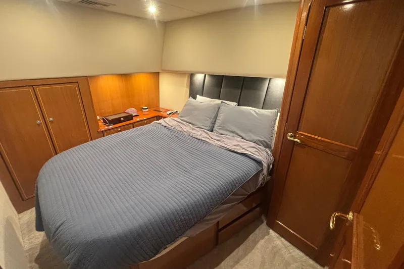 Pipe Dream Yacht Photos Pics Cozy bedroom in 2005 Ocean Yachts 50 Super Sport with wood accents and comfortable bedding.