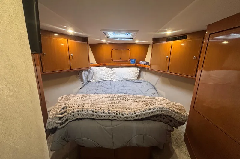 Pipe Dream Yacht Photos Pics Luxurious cabin interior of 2005 Ocean Yachts 50 Super Sport with cozy bedding and wooden cabinets.