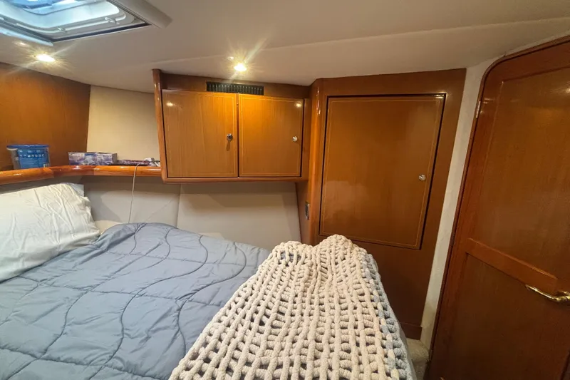 Pipe Dream Yacht Photos Pics Cozy cabin interior of 2005 Ocean Yachts 50 Super Sport with wooden cabinets and bedding.
