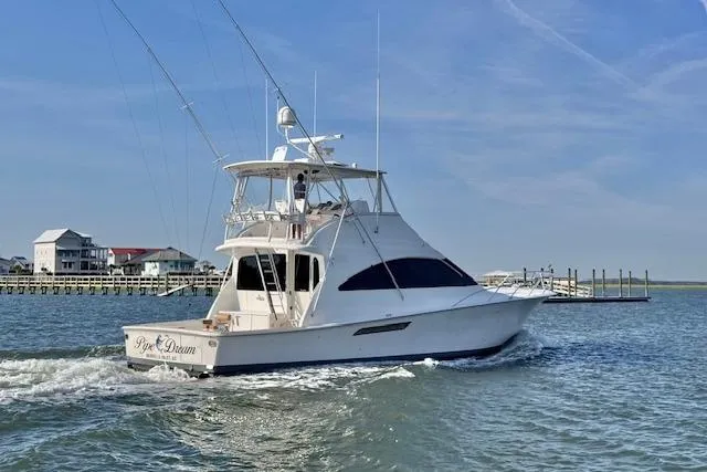 Pipe Dream Yacht Photos Pics 2005 Ocean Yachts 50 Super Sport cruising on a sunny day near a coastal dock.