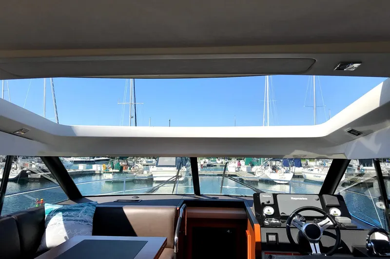  Yacht Photos Pics Interior view of 2017 Prestige 420S Coupé yacht at marina, showcasing helm and seating area.