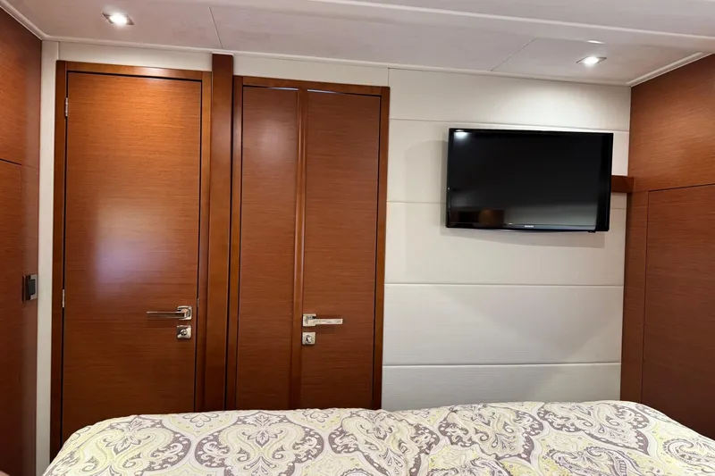  Yacht Photos Pics Interior of 2017 Prestige 420S Coupé with wooden doors, wall-mounted TV, and patterned bedding.