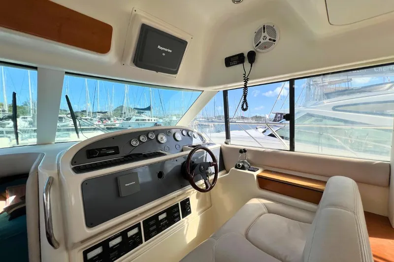  Yacht Photos Pics Interior helm of 2005 Jeanneau Prestige 36 yacht with modern controls and marina view.