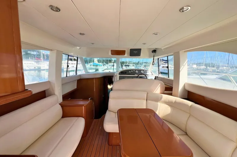  Yacht Photos Pics Luxurious interior of 2005 Jeanneau Prestige 36 yacht with plush seating and wooden accents.
