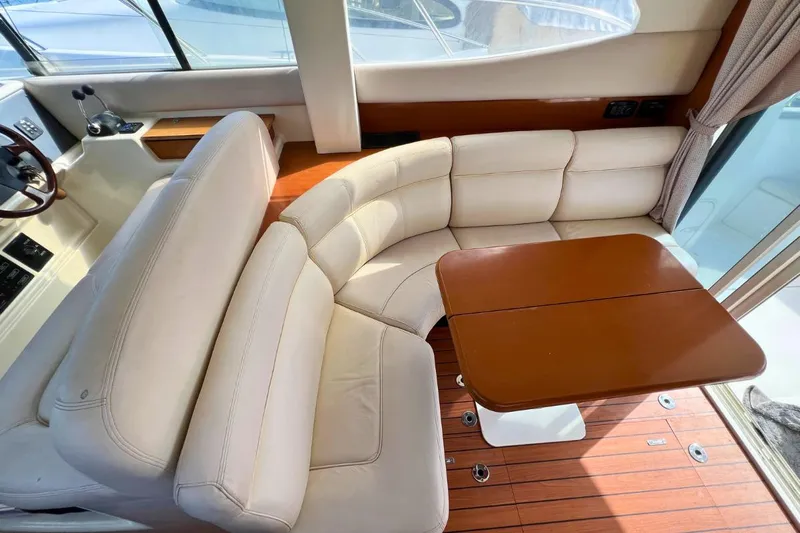  Yacht Photos Pics Luxurious interior of 2005 Jeanneau Prestige 36 yacht with plush seating and wooden table.